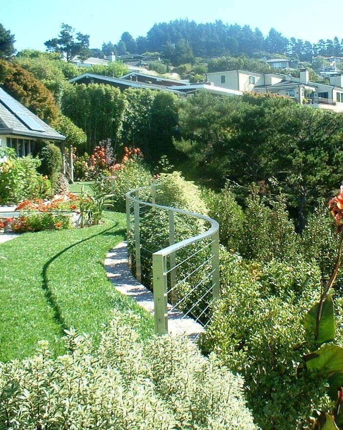 Cette photo montre un grand jardin à la française tendance avec un mur de soutènement, une exposition ensoleillée, une pente, une colline ou un talus et des pavés en brique.