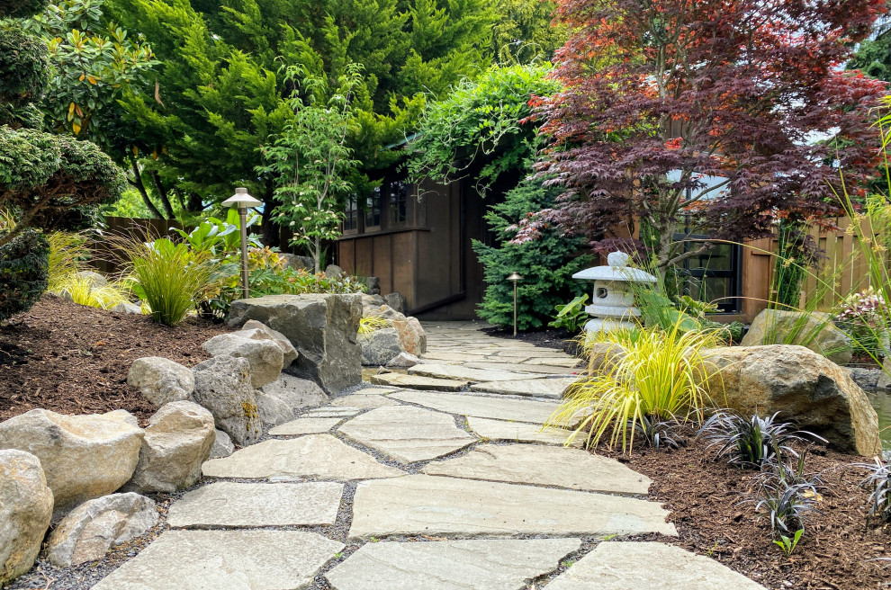 Imagen de jardín asiático de tamaño medio en patio trasero con jardín francés, camino de entrada y adoquines de piedra natural
