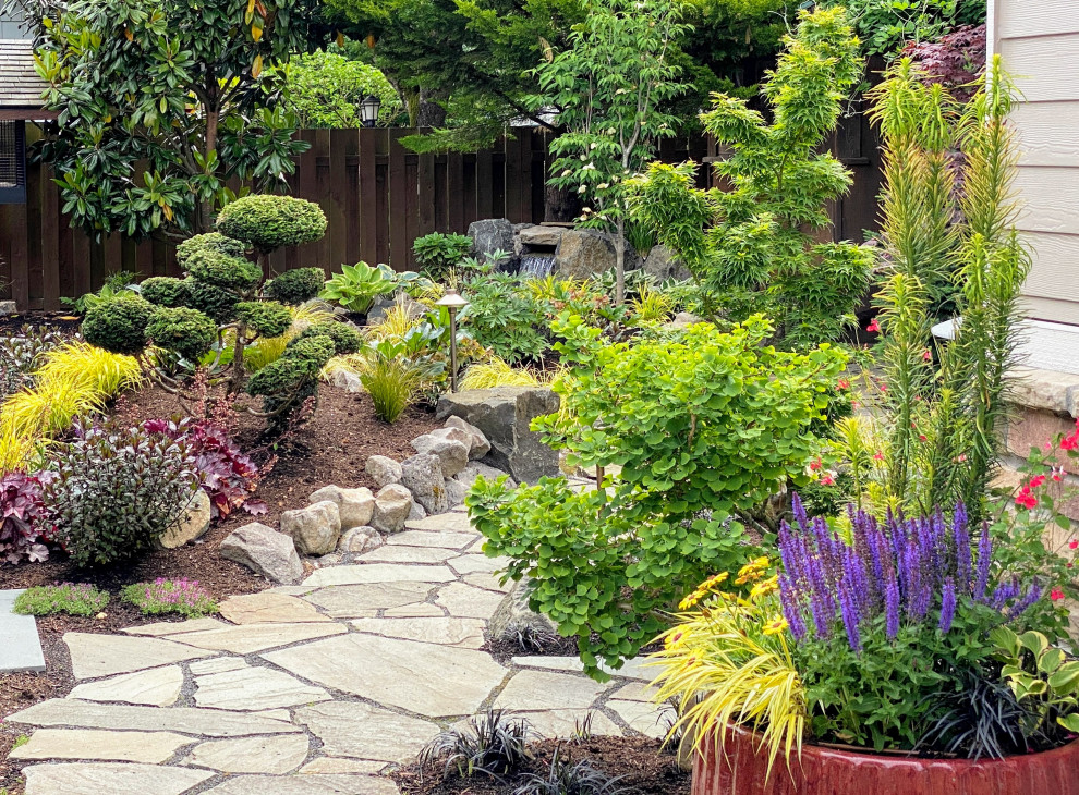 Imagen de jardín asiático de tamaño medio en patio trasero con jardín francés, jardín de macetas y adoquines de piedra natural