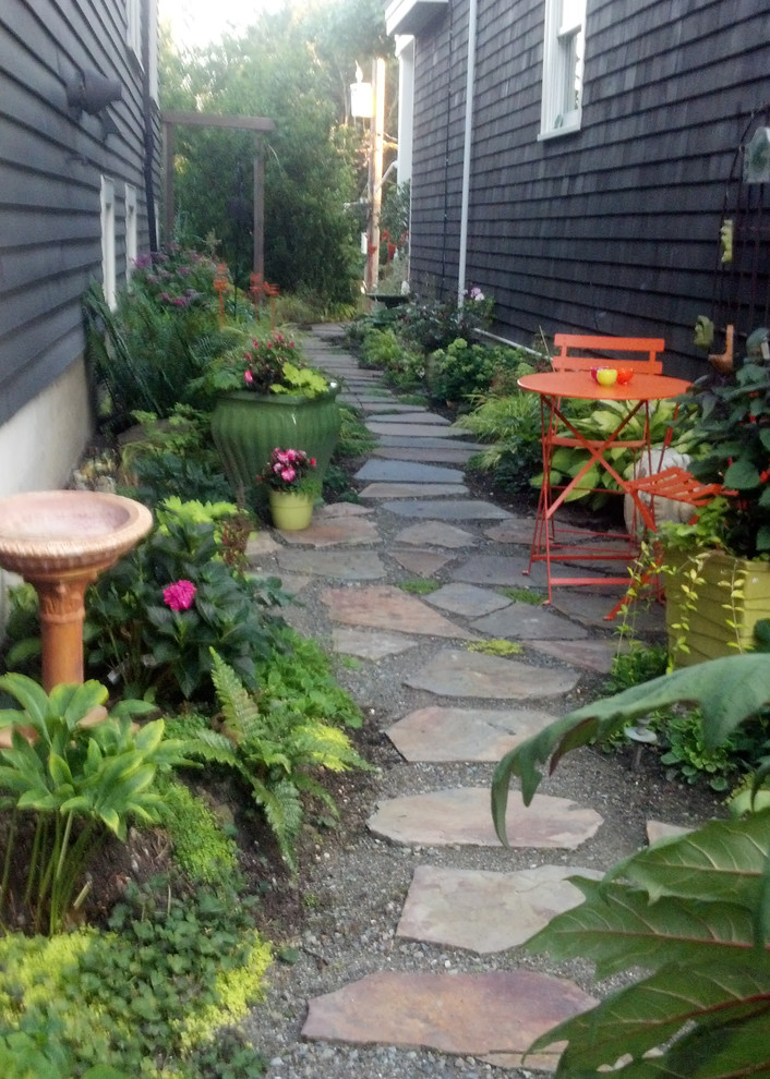 Bild på en liten eklektisk trädgård i skuggan längs med huset, med naturstensplattor