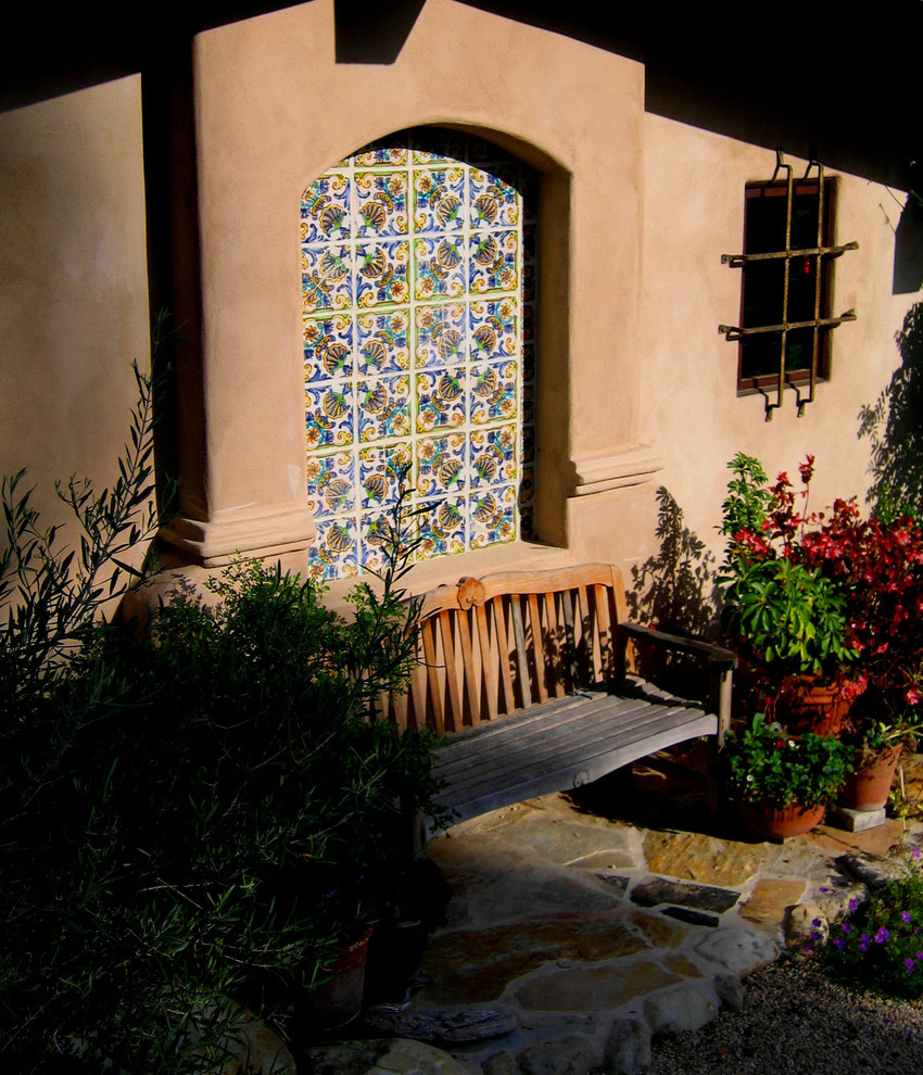 Esempio di un giardino xeriscape mediterraneo esposto in pieno sole di medie dimensioni e in cortile in primavera con un ingresso o sentiero e pavimentazioni in pietra naturale