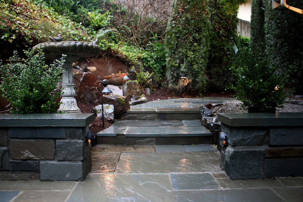 Cette image montre un jardin à la française arrière traditionnel avec des pavés en pierre naturelle.