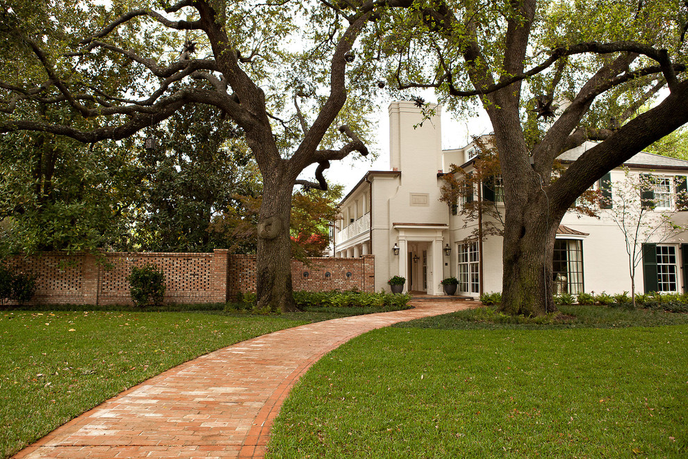 This is an example of a large traditional front garden in Dallas with brick paving.