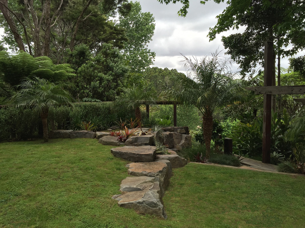 Foto di un ampio giardino etnico esposto in pieno sole in estate con un pendio, una collina o una riva e pavimentazioni in pietra naturale