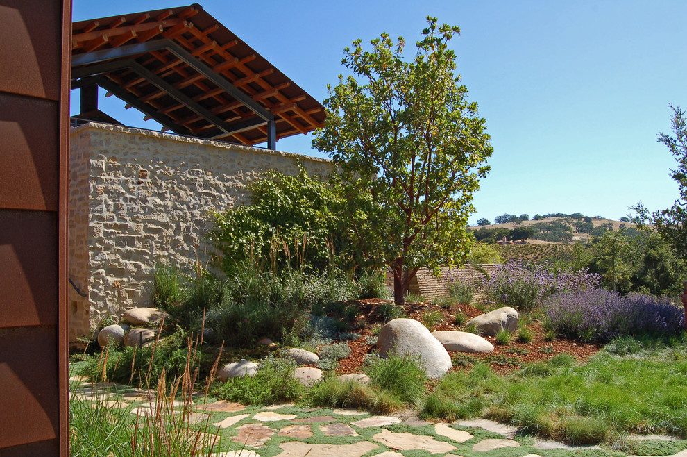 Diseño de jardín mediterráneo con exposición total al sol y adoquines de piedra natural