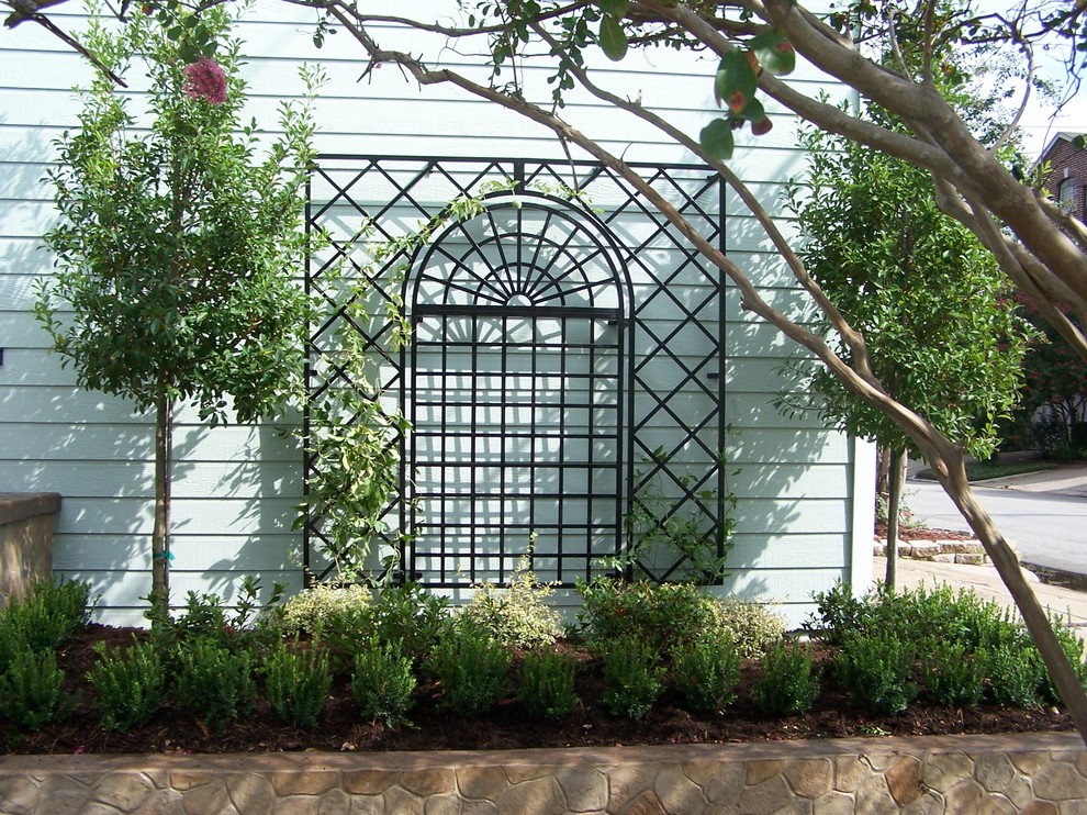 Esempio di un piccolo giardino classico esposto a mezz'ombra in primavera con un muro di contenimento, un pendio, una collina o una riva e pavimentazioni in cemento