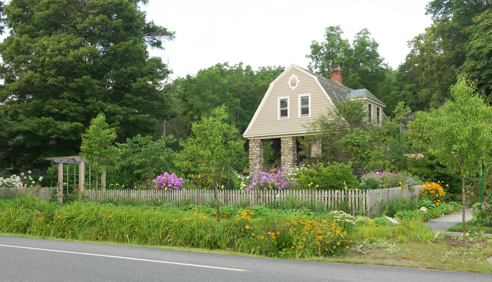 Bild på en mellanstor amerikansk trädgård framför huset, med en trädgårdsgång