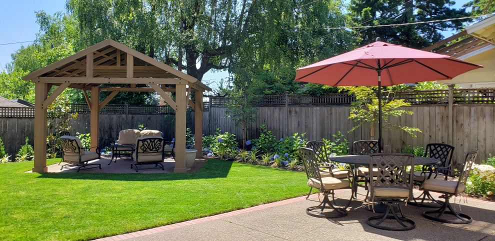 Photo of a mid-sized traditional full sun backyard brick and wood fence landscaping in Portland for summer.