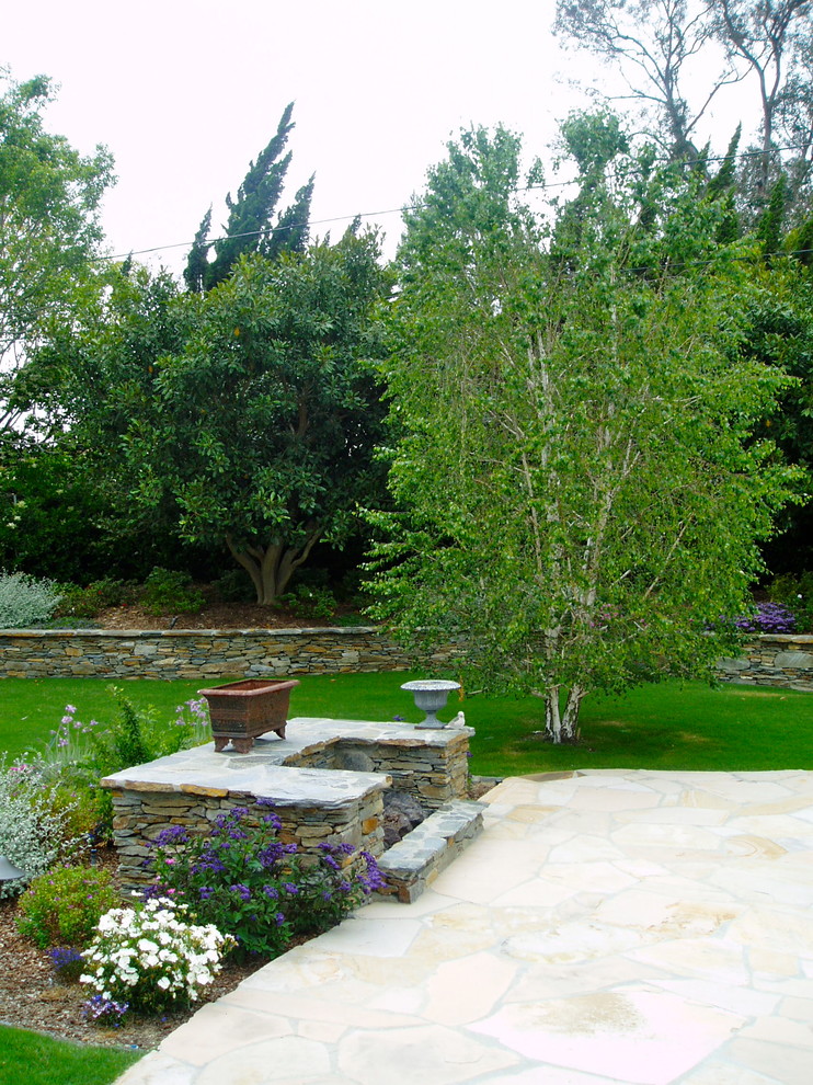 This is an example of a traditional full sun backyard stone landscaping in San Diego with a fire pit.