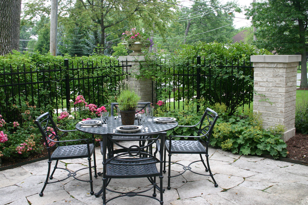 Immagine di un patio o portico classico nel cortile laterale e di medie dimensioni con pavimentazioni in pietra naturale