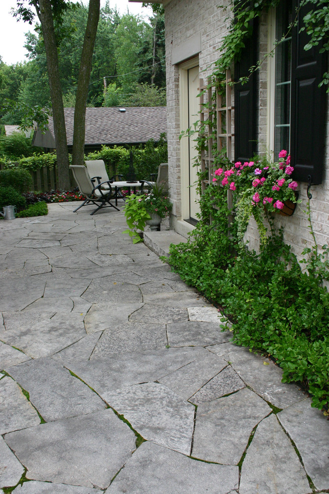 Foto di un giardino chic esposto a mezz'ombra dietro casa e di medie dimensioni in estate con pavimentazioni in pietra naturale e un ingresso o sentiero