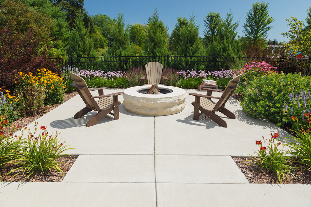 Diseño de jardín de secano clásico de tamaño medio en verano en patio trasero con brasero y exposición total al sol