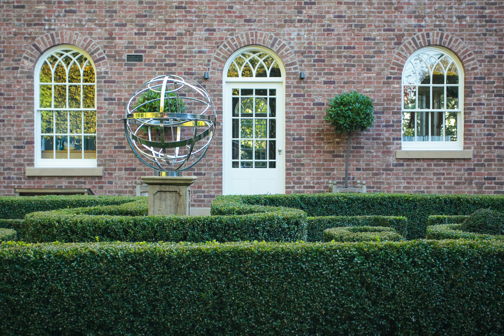 На фото: регулярный сад на внутреннем дворе в классическом стиле с полуденной тенью с