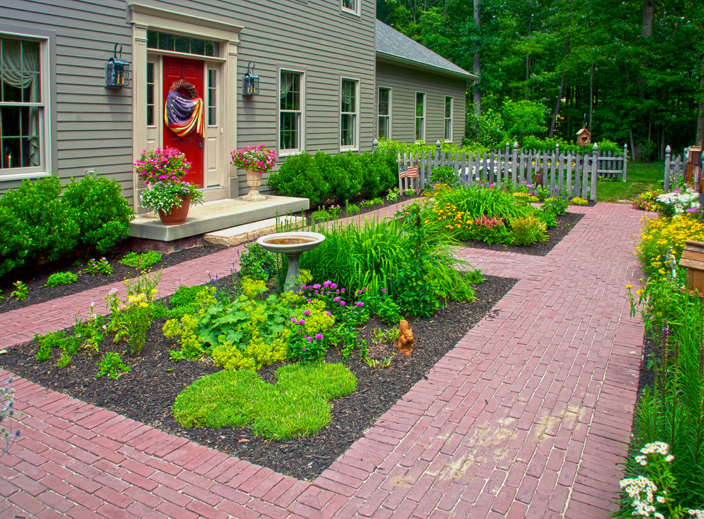 Esempio di un giardino country esposto a mezz'ombra davanti casa e di medie dimensioni con un ingresso o sentiero e pavimentazioni in mattoni