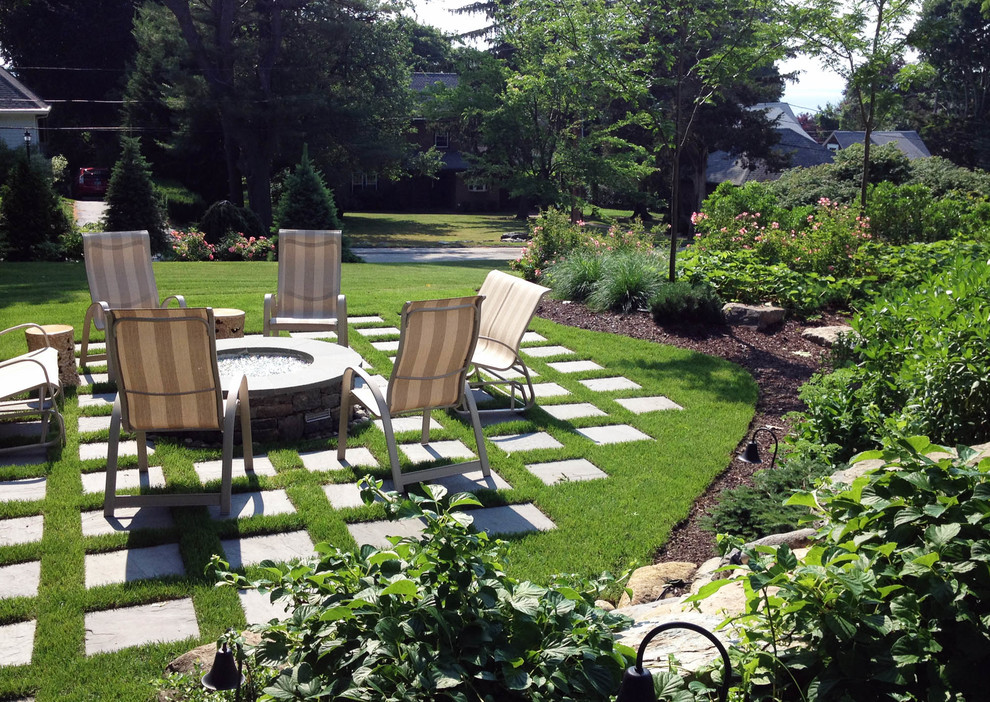 Foto de jardín clásico de tamaño medio en verano en patio trasero con brasero, exposición parcial al sol y adoquines de piedra natural