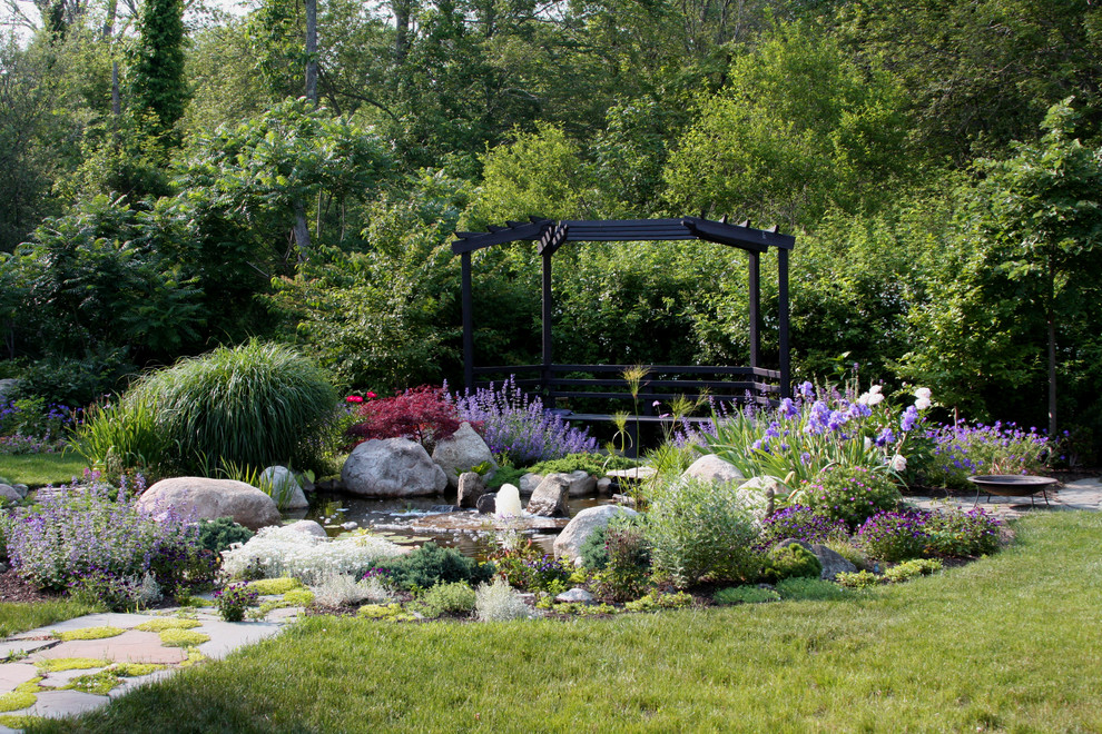 Idées déco pour un jardin arrière classique l'été avec un point d'eau et des pavés en pierre naturelle.
