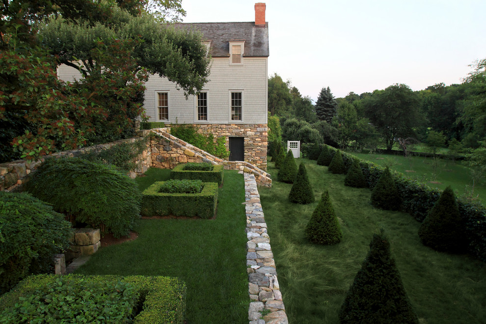 Modelo de jardín clásico grande en patio trasero con jardín francés