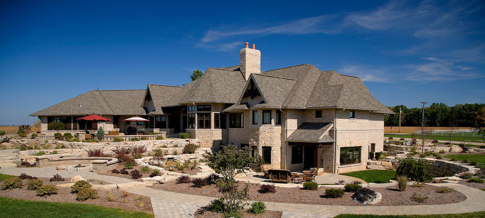 Inspiration for a huge traditional full sun backyard stone landscaping in Other for summer.