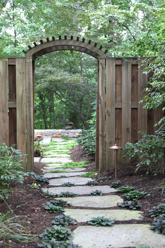 Idée de décoration pour un aménagement d'entrée ou allée de jardin tradition avec une exposition ombragée et des pavés en pierre naturelle.