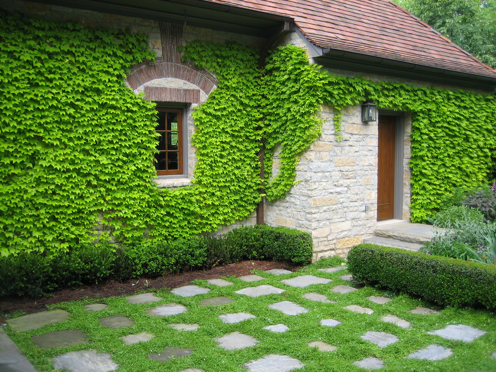 Bild på en vintage trädgård, med en vertikal trädgård och naturstensplattor
