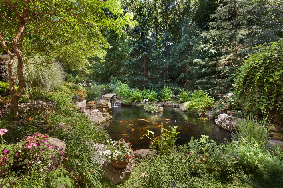 Inspiration för en mycket stor vintage formell trädgård i slänt på sommaren, med en damm