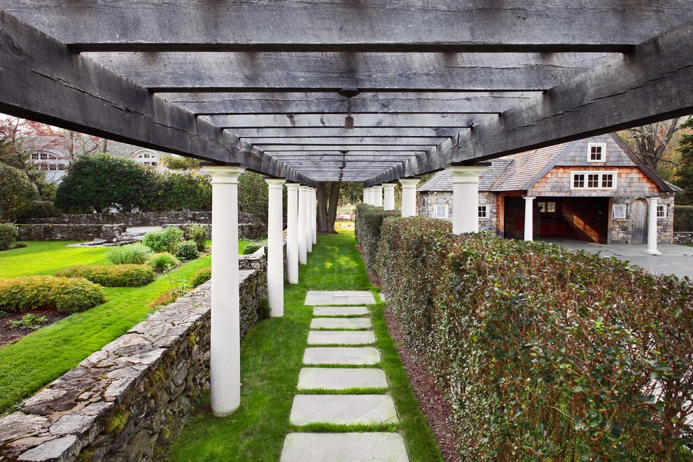 Klassischer Garten hinter dem Haus mit Natursteinplatten und Pergola in New York