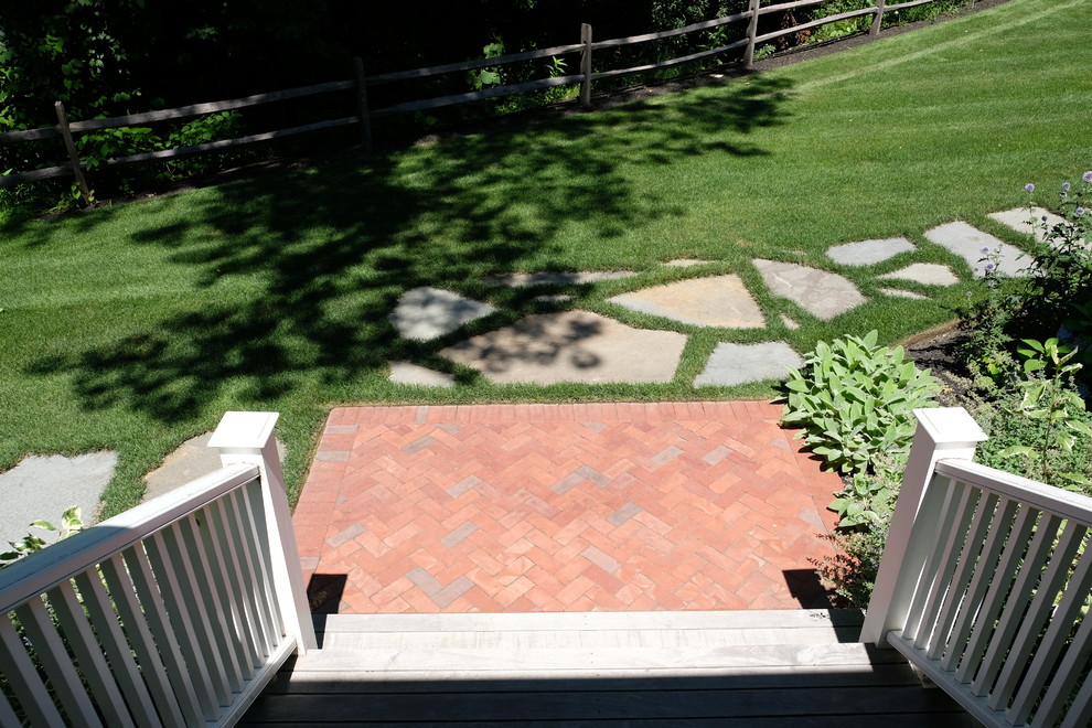 Cette image montre un jardin arrière traditionnel de taille moyenne et l'été avec une exposition ensoleillée et des pavés en brique.