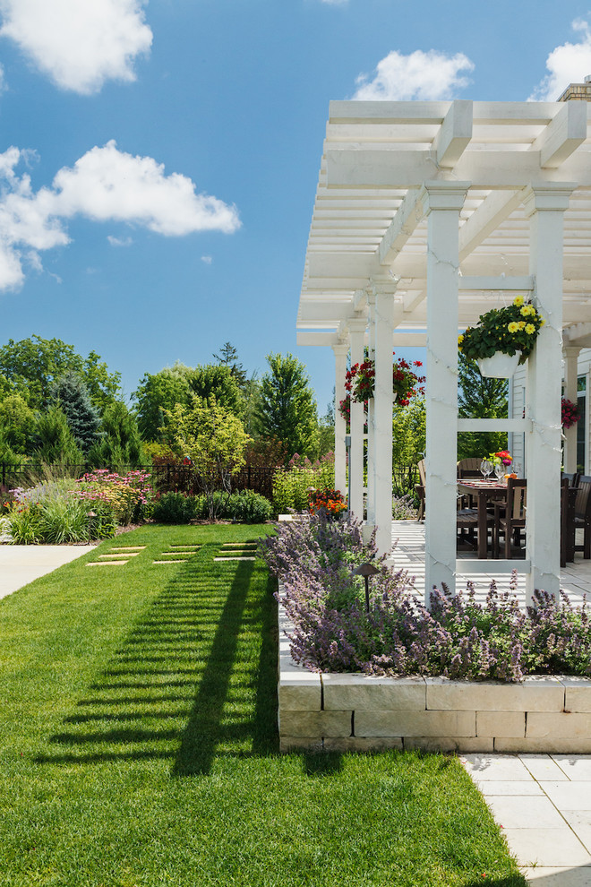 Idee per un giardino xeriscape classico esposto in pieno sole di medie dimensioni e dietro casa in estate con un muro di contenimento e pavimentazioni in pietra naturale