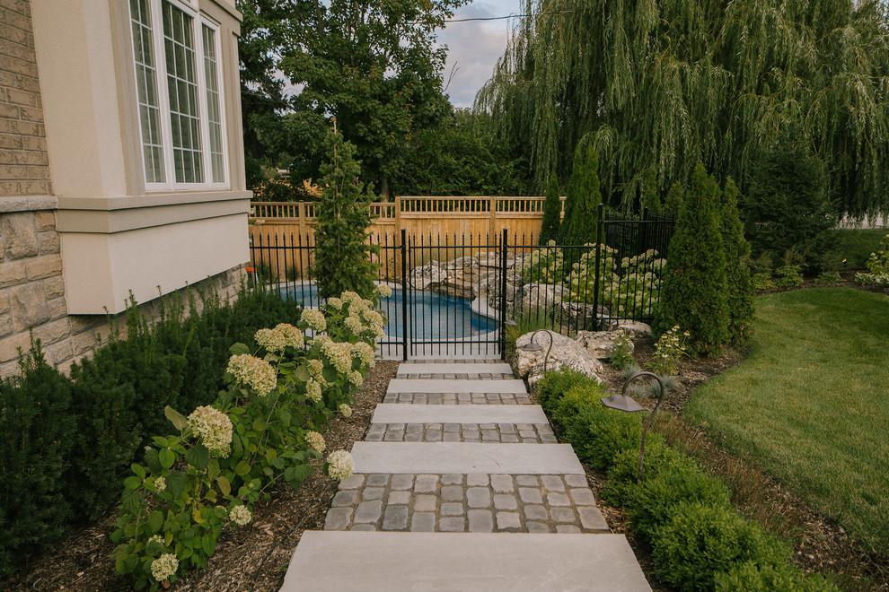 Стильный дизайн: участок и сад среднего размера на боковом дворе в классическом стиле с садовой дорожкой или калиткой и мощением тротуарной плиткой - последний тренд