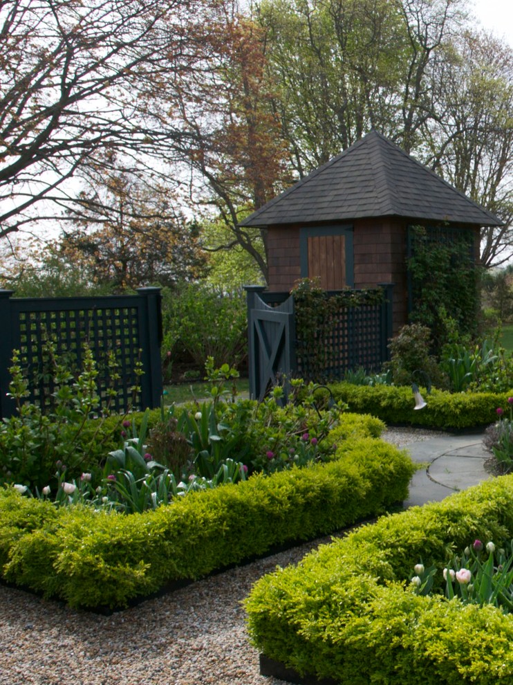 Idée de décoration pour un petit jardin à la française arrière tradition au printemps avec du gravier.