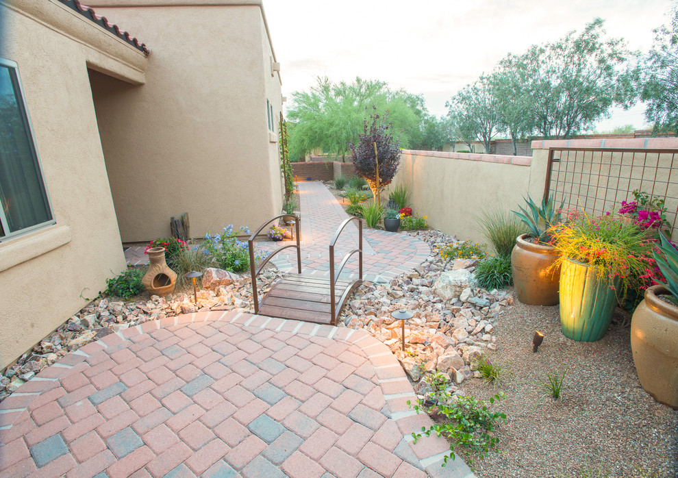 Inspiration for a mid-sized southwestern drought-tolerant and partial sun side yard brick garden path in Phoenix.