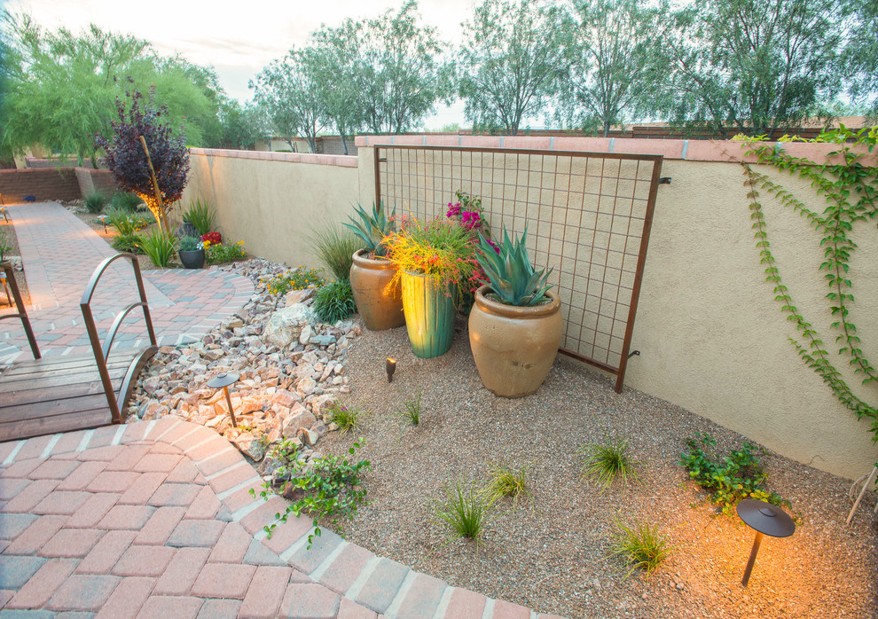 Пример оригинального дизайна: засухоустойчивый сад среднего размера на боковом дворе в стиле фьюжн с полуденной тенью, мощением клинкерной брусчаткой и пустынными растениями