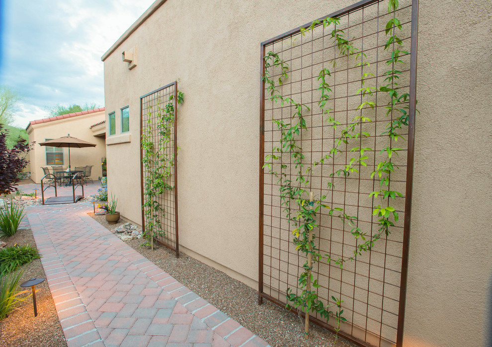 Immagine di un giardino xeriscape stile americano esposto a mezz'ombra nel cortile laterale e di medie dimensioni con un ingresso o sentiero e pavimentazioni in mattoni