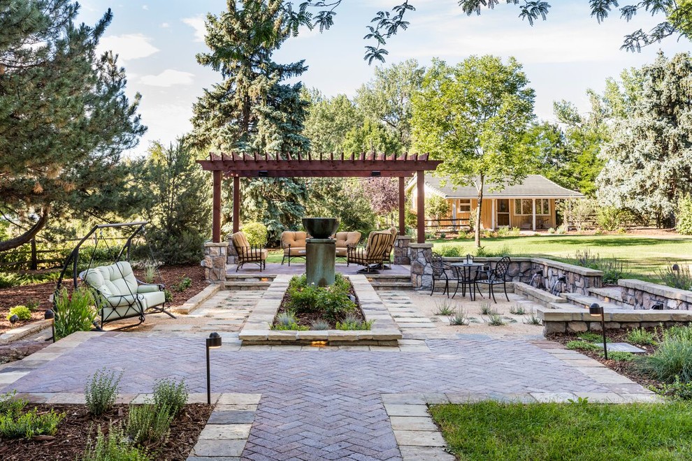 Foto de jardín mediterráneo grande en verano en patio trasero con jardín francés, fuente, exposición total al sol y adoquines de piedra natural