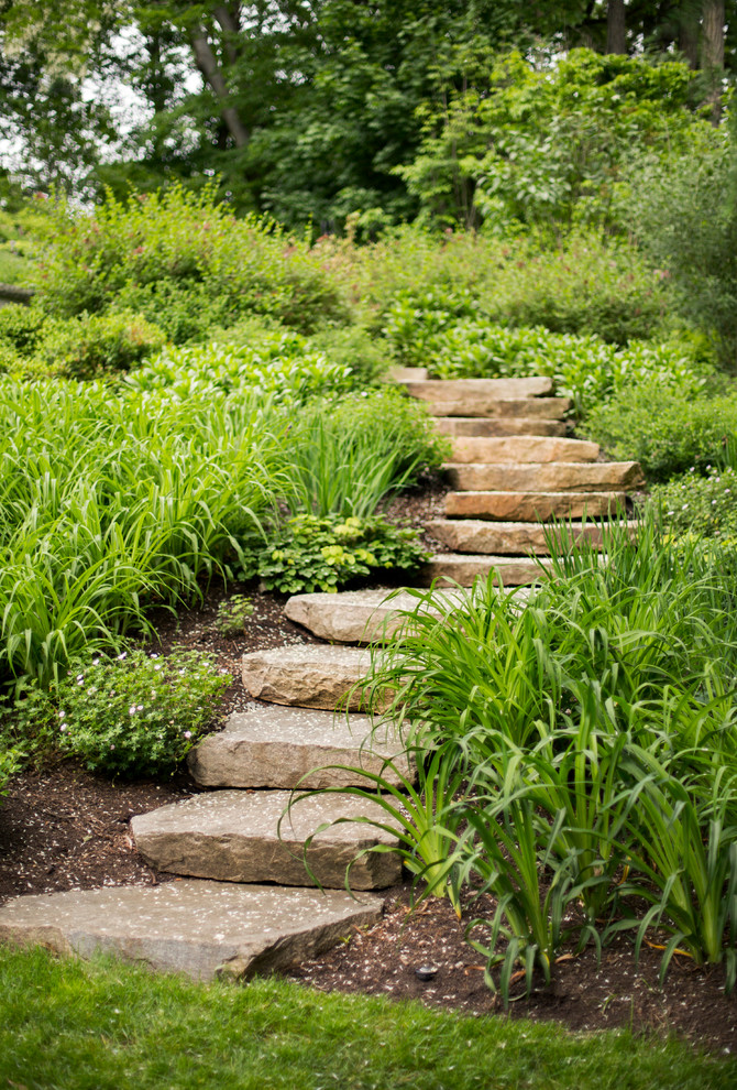 Idée de décoration pour un jardin tradition avec une pente, une colline ou un talus et des pavés en pierre naturelle.