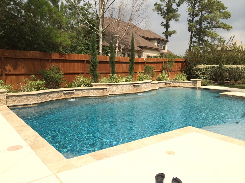 Foto di una piscina chic personalizzata di medie dimensioni e dietro casa con lastre di cemento e una vasca idromassaggio