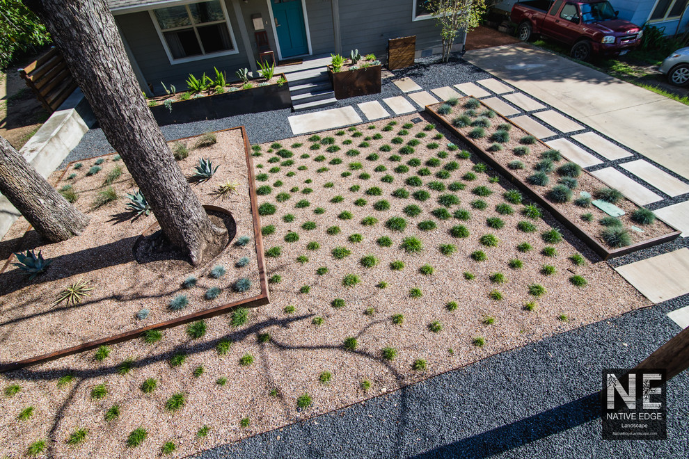 Exempel på en mellanstor modern trädgård som tål torka och framför huset, med en trädgårdsgång och marksten i betong