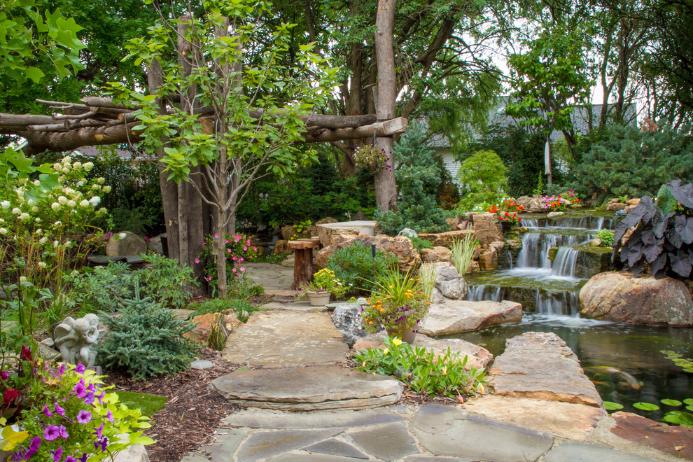 Imagen de jardín clásico en patio trasero con fuente
