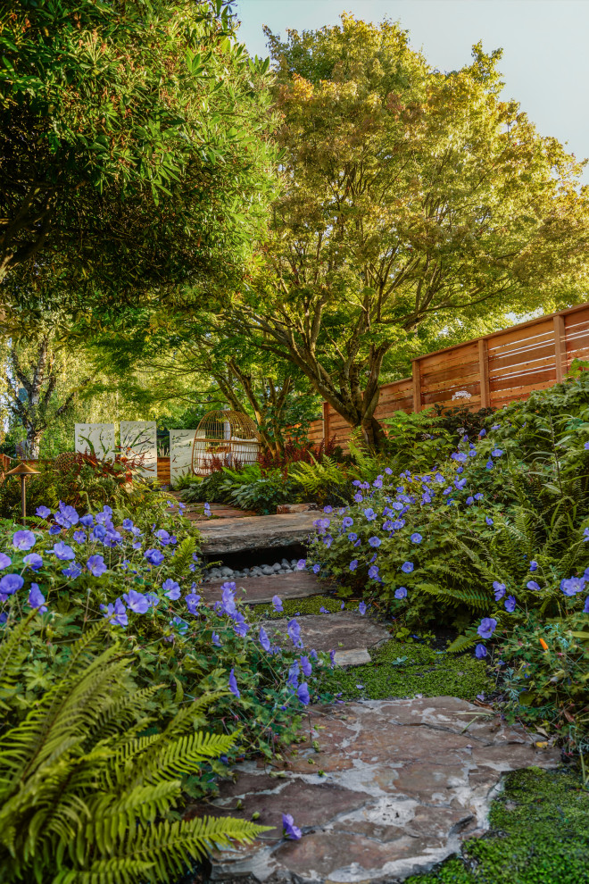 Cette photo montre un jardin arrière éclectique de taille moyenne avec un chemin, une exposition partiellement ombragée et des pavés en pierre naturelle.