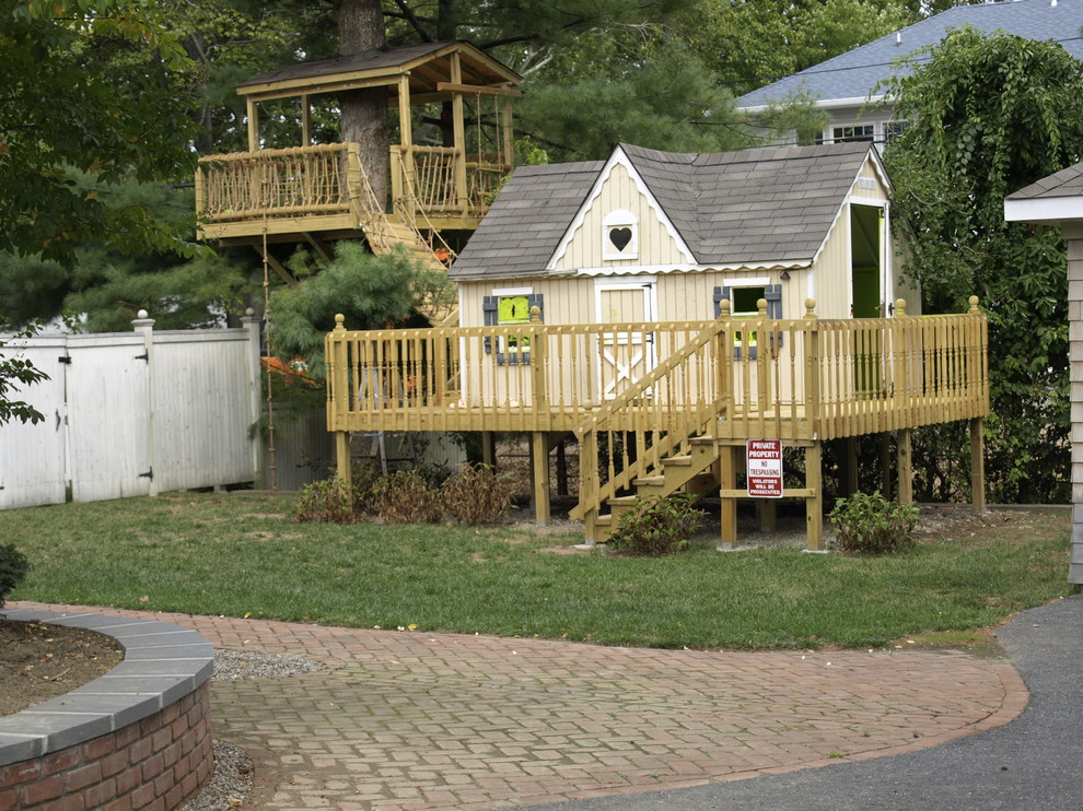 Ejemplo de jardín clásico en patio trasero con parque infantil y adoquines de ladrillo