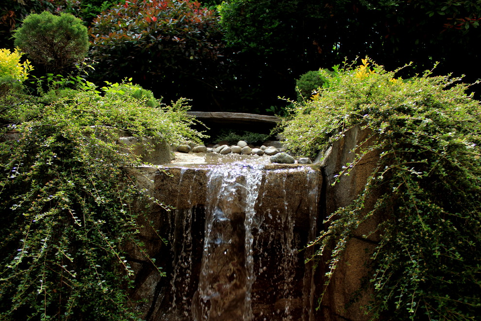 Aménagement d'un jardin arrière classique de taille moyenne avec un bassin, une exposition partiellement ombragée et des pavés en pierre naturelle.