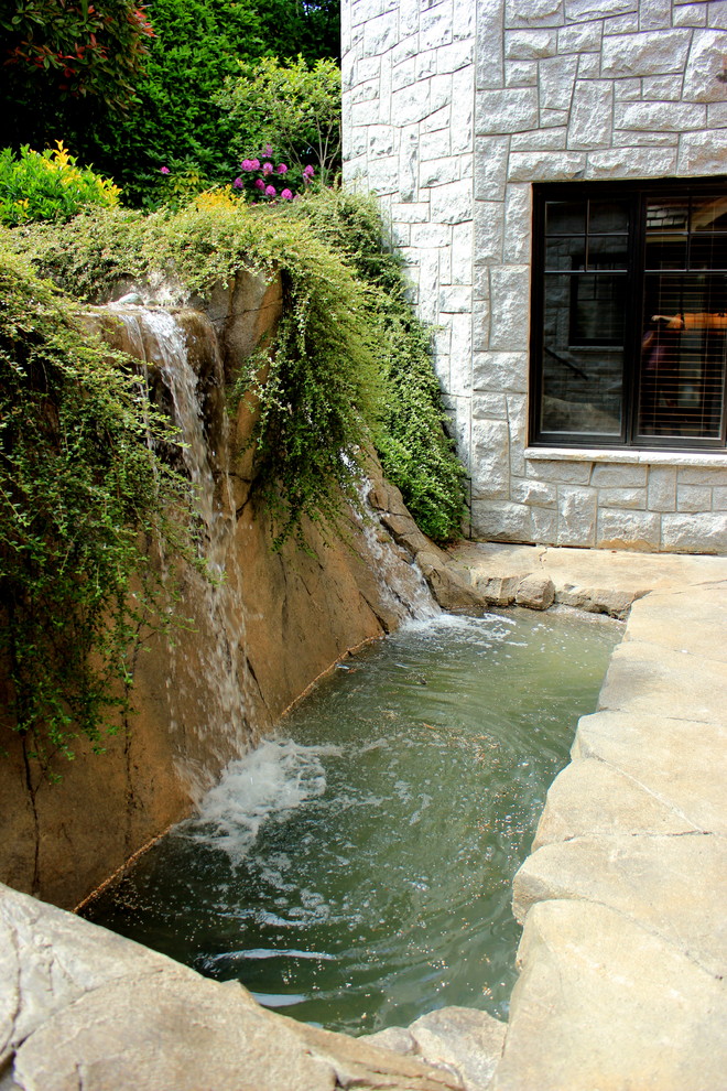 Exemple d'un jardin arrière chic de taille moyenne avec un bassin, une exposition partiellement ombragée et des pavés en pierre naturelle.