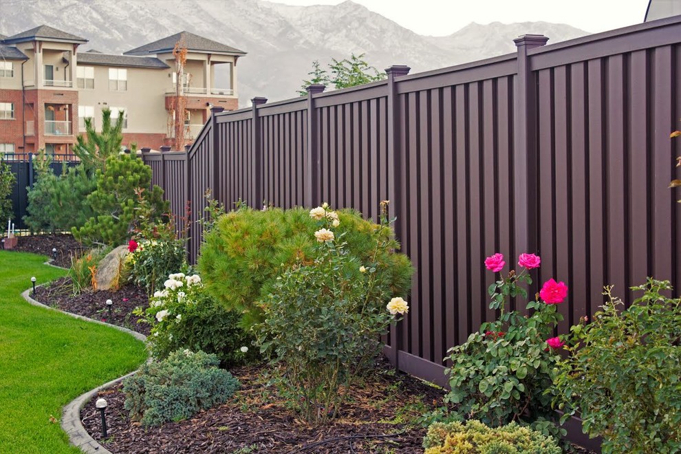 Immagine di un grande giardino formale chic esposto a mezz'ombra dietro casa in estate con pacciame e recinzione in PVC