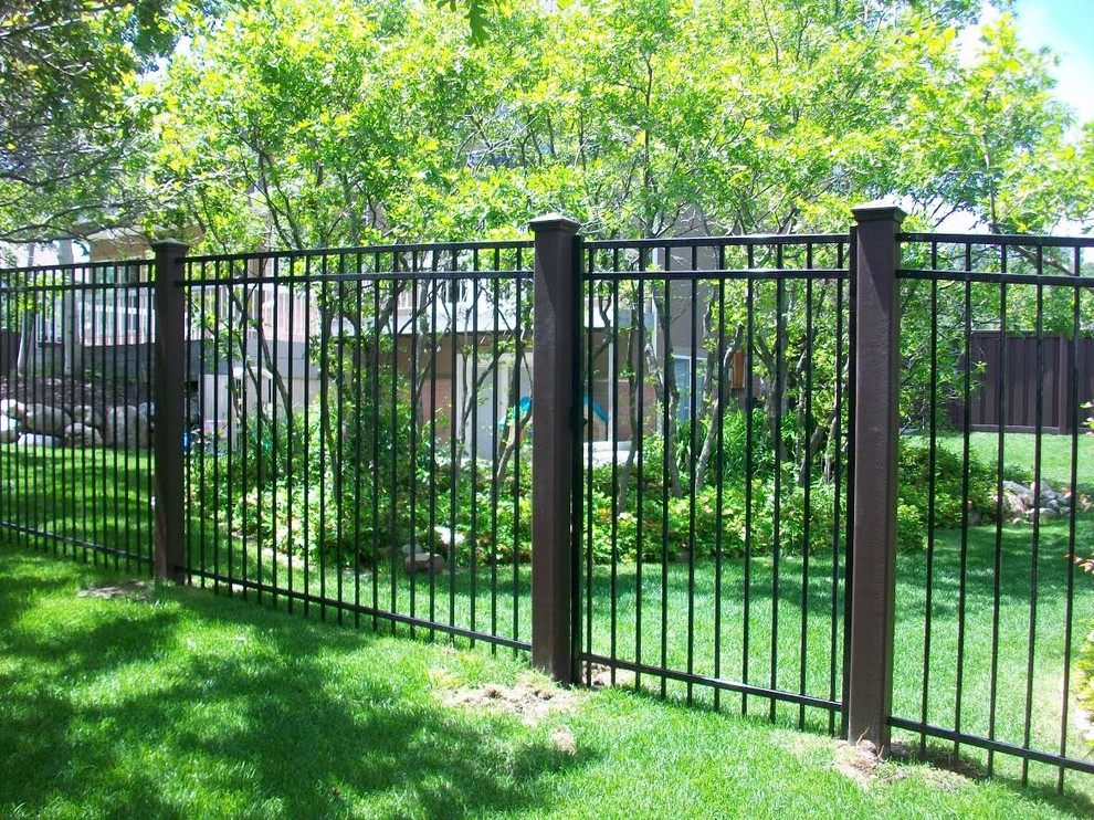 На фото: большой весенний участок и сад на заднем дворе в стиле неоклассика (современная классика) с полуденной тенью, забором и с металлическим забором