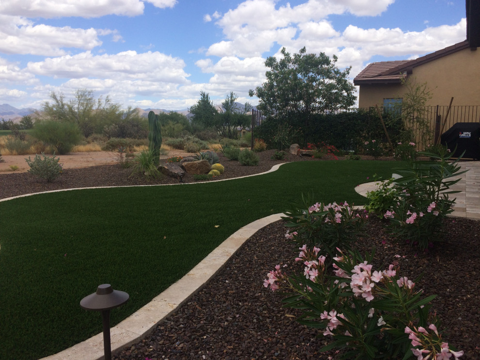 Mediterraner Garten hinter dem Haus mit Wüstengarten, direkter Sonneneinstrahlung und Natursteinplatten in Phoenix