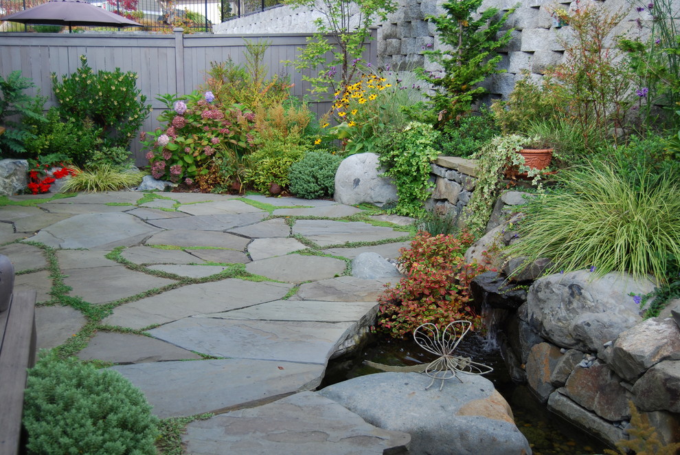 Пример оригинального дизайна: солнечный, летний регулярный сад среднего размера на заднем дворе в классическом стиле с подпорной стенкой, хорошей освещенностью и покрытием из каменной брусчатки