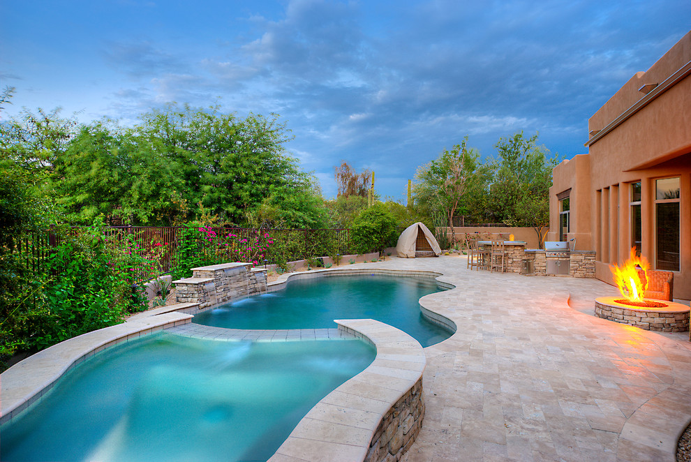 Idée de décoration pour une grande piscine arrière sud-ouest américain avec des pavés en pierre naturelle.