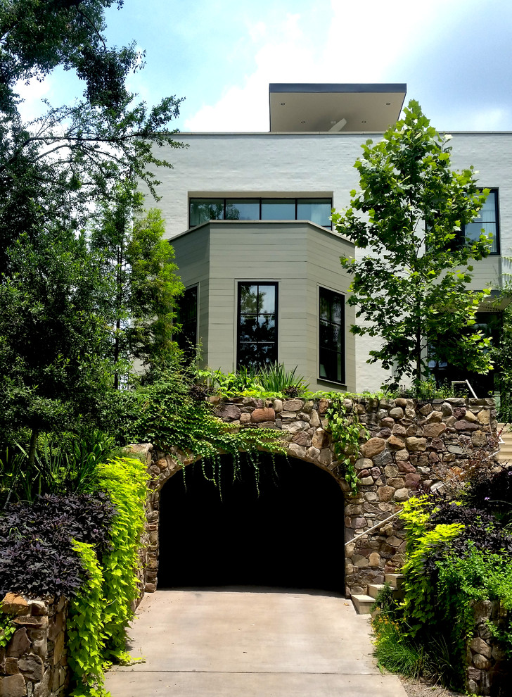 На фото: участок и сад на склоне в современном стиле с подпорной стенкой