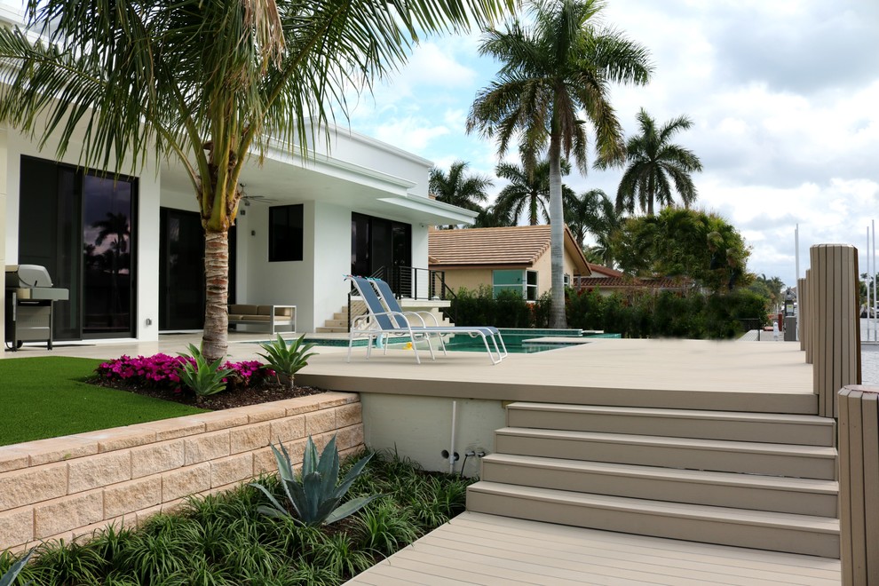 Geometrische Moderne Gartenmauer im Sommer, hinter dem Haus mit direkter Sonneneinstrahlung und Betonboden in Sonstige