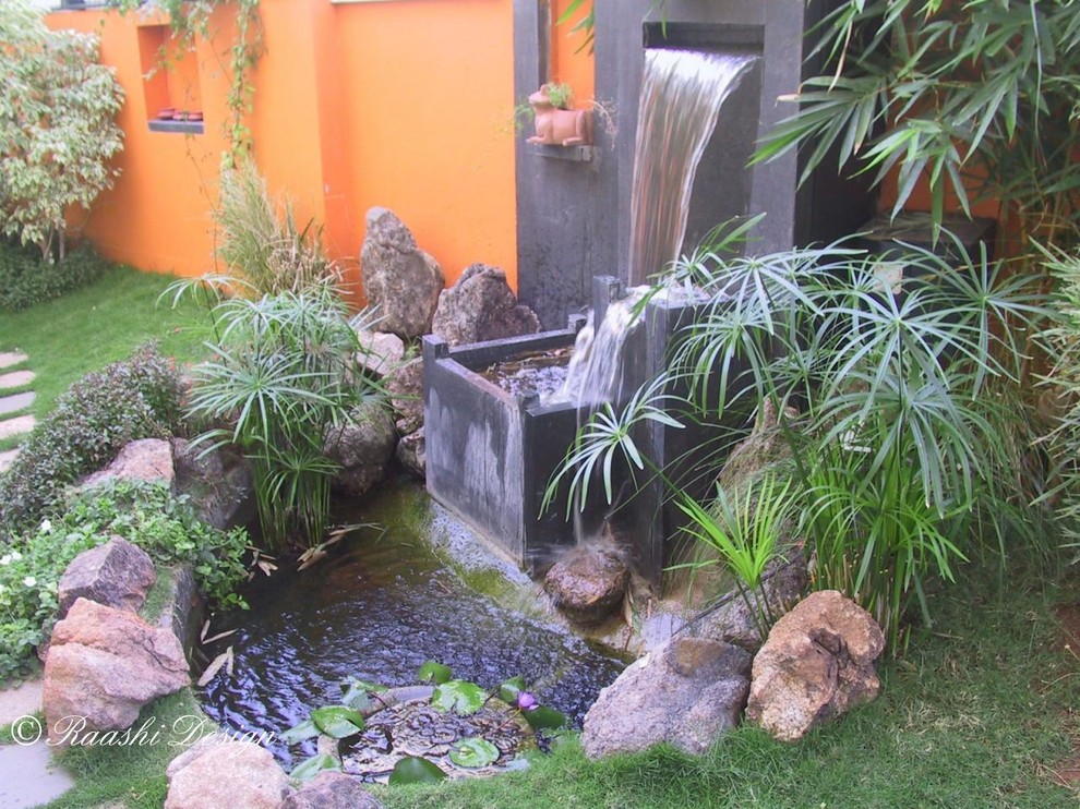Aménagement d'un jardin arrière exotique de taille moyenne avec un point d'eau et des pavés en pierre naturelle.